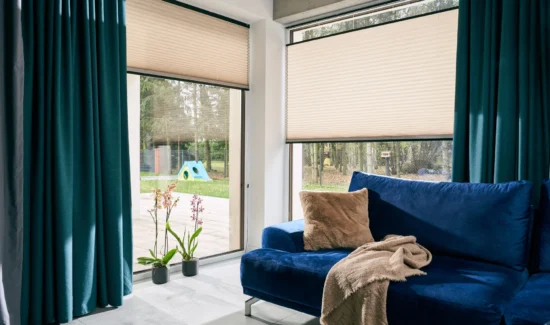 Modernes Wohnzimmer mit blauen Sofa und großen Fenstern