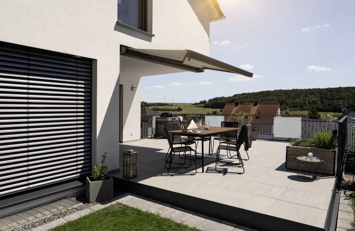 Moderne Terrasse mit Sonnenschutz und Sitzmöbeln